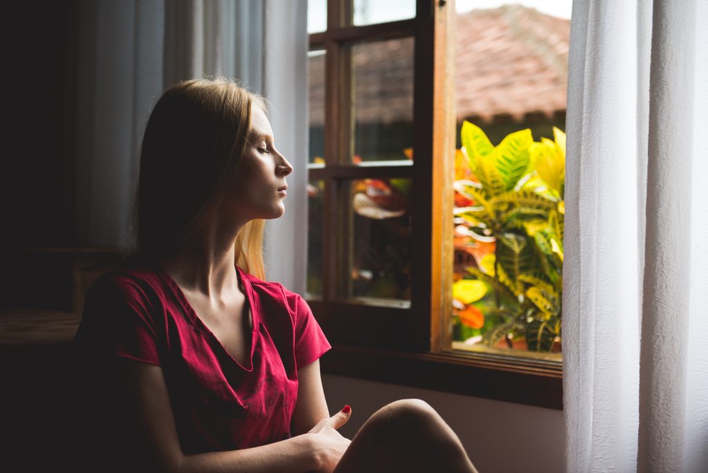 woman looking out the window thoughtfully