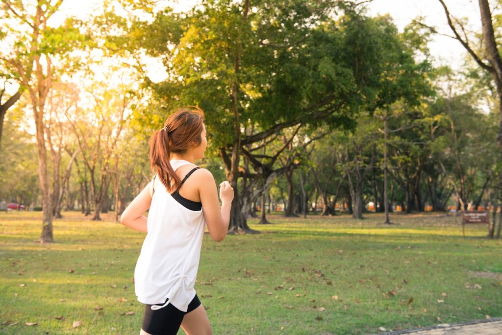 woman running with sunbeams behind her