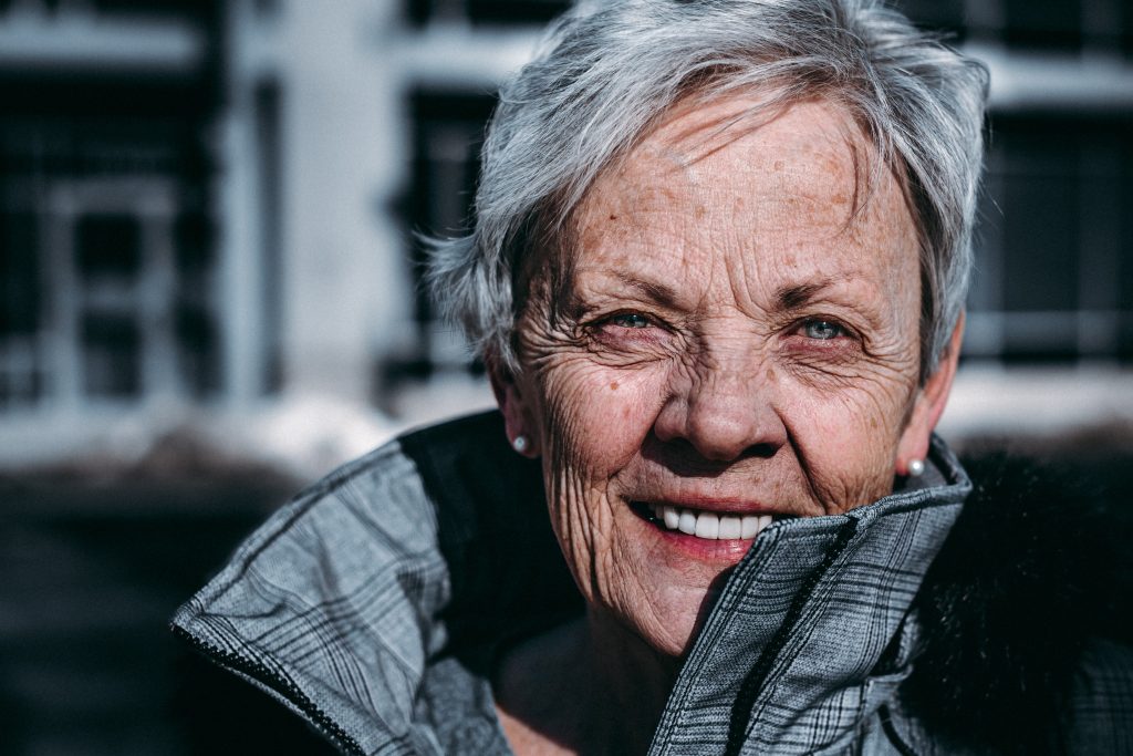 older woman smiling in sunlight