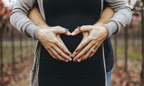 heart hands shape over pregnant belly