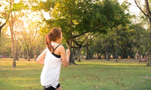 woman running with sunbeams behind her